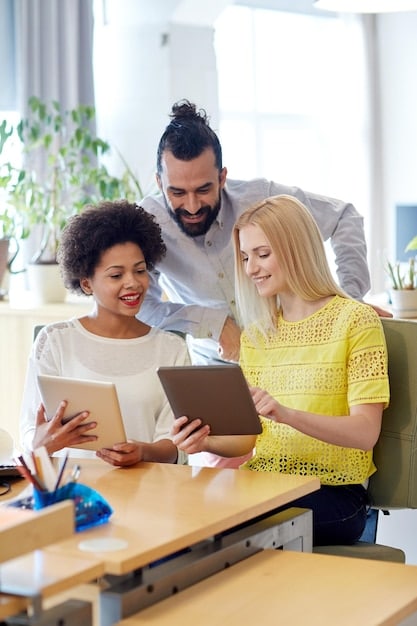 A diverse group of international individuals smiling and confidently consulting financial documents together at a bright, modern co-working space.