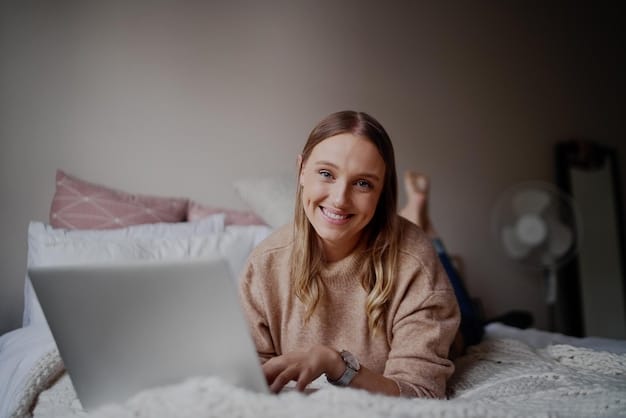 A young woman smiles happily while video chatting on her laptop in her dorm room. She is using headphones and seems to be talking with relatives, emphasizing the support system. The scene is casual and pleasant, the image portrays emotional connections maintained via modern technology.