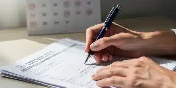 Hands filling out disability benefits application forms for 2026